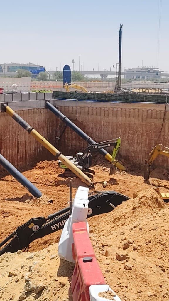 Large-scale site excavation with diagonal struts and active earthmoving